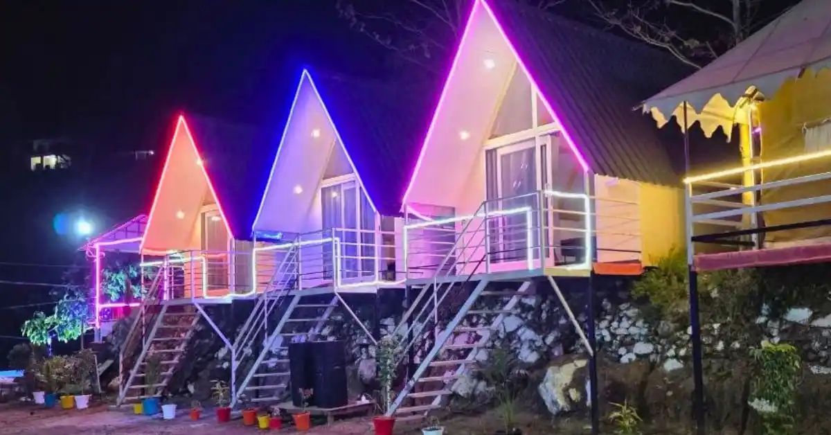 Valencia River Resort A-frame cottages at night with neon lights